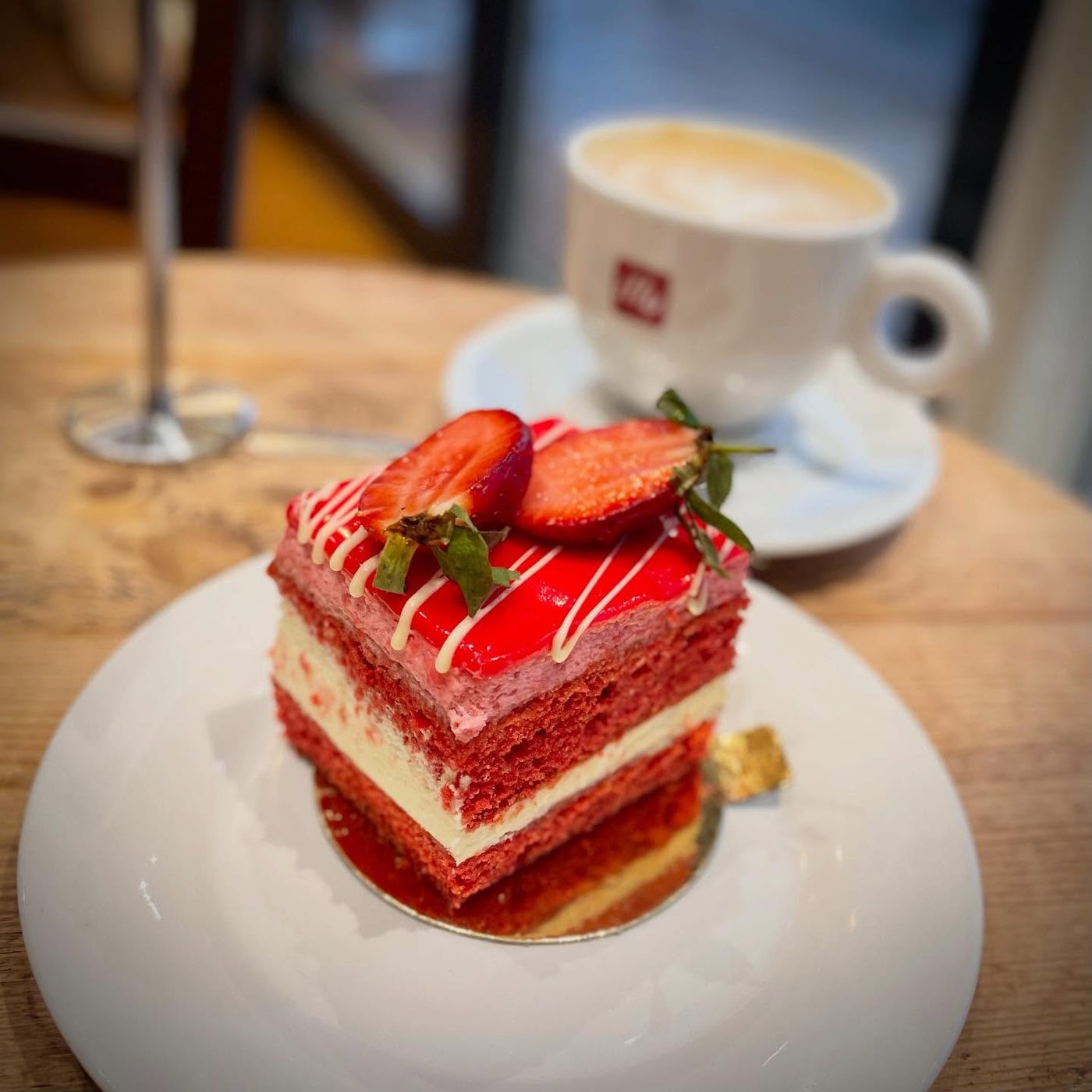 A slice of Red Mousse cake with a cappuccino