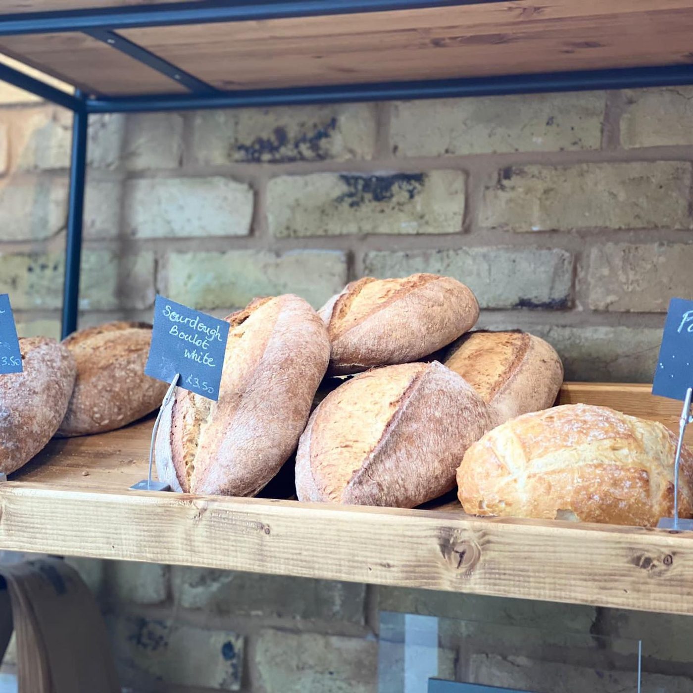 Sourdough boules and bâtards on a wooden shelf